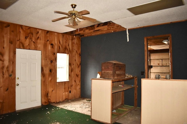 misc room with ceiling fan and wood walls