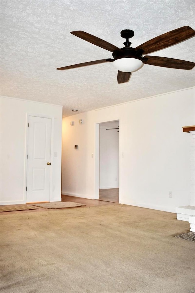 empty room with carpet flooring, ceiling fan, and a textured ceiling