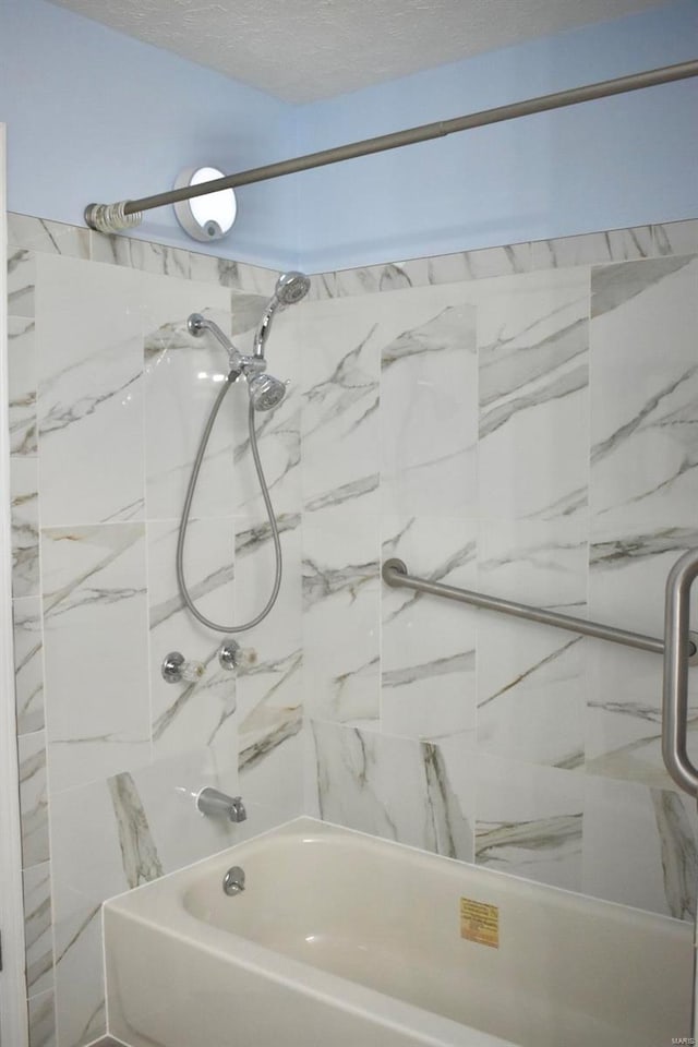 bathroom featuring tiled shower / bath combo and a textured ceiling