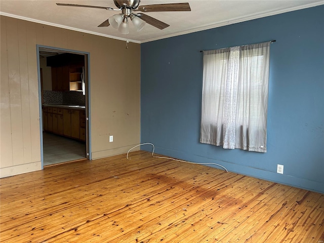 unfurnished room featuring light wood-type flooring, ceiling fan, and ornamental molding