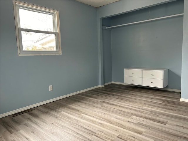 unfurnished bedroom featuring a closet and light wood-type flooring