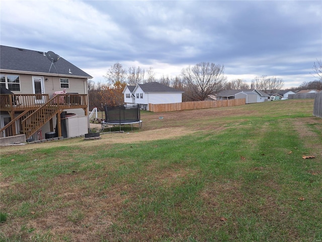 view of yard featuring a deck and a trampoline