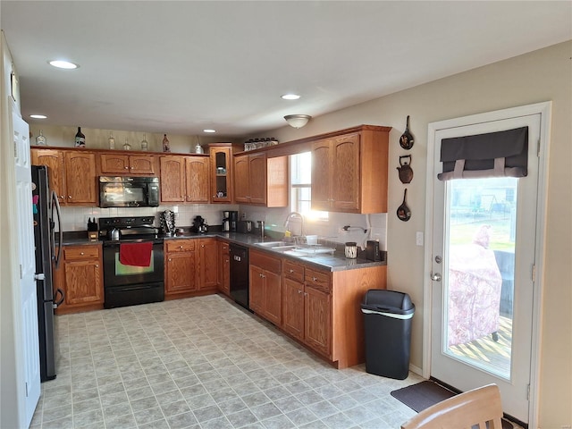 kitchen with black appliances, decorative backsplash, and sink