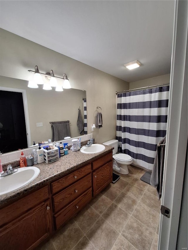 bathroom with tile patterned flooring, vanity, and toilet