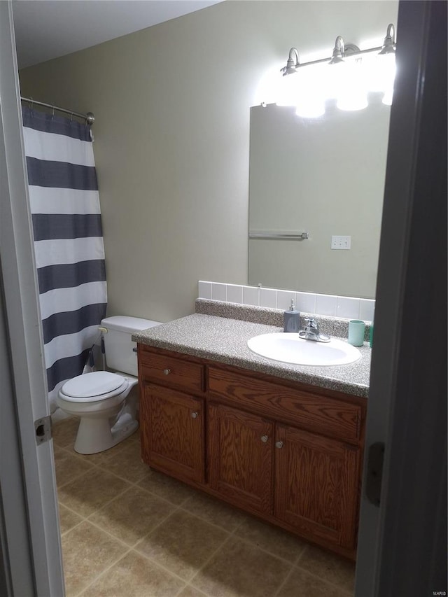 bathroom featuring tile patterned floors, vanity, and toilet