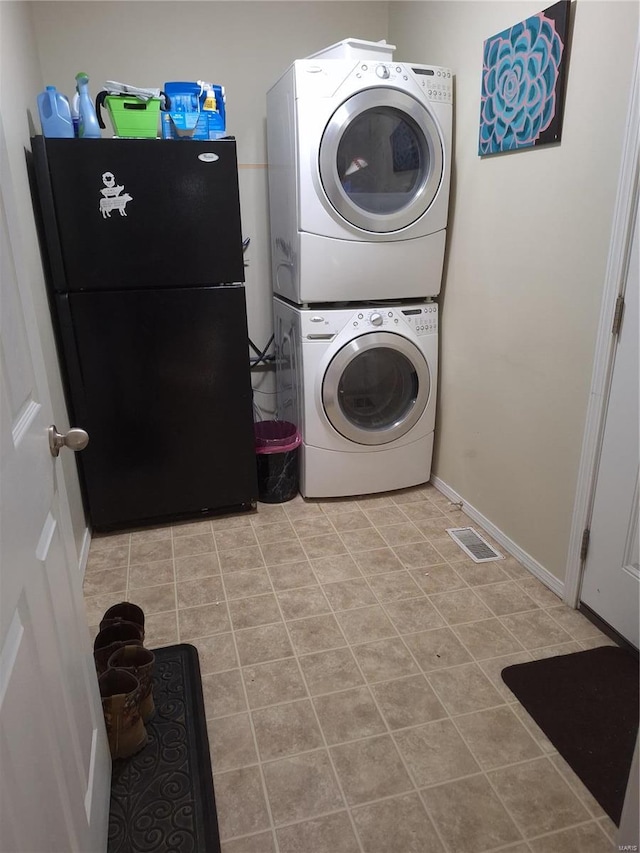 washroom featuring light tile patterned floors and stacked washer / dryer