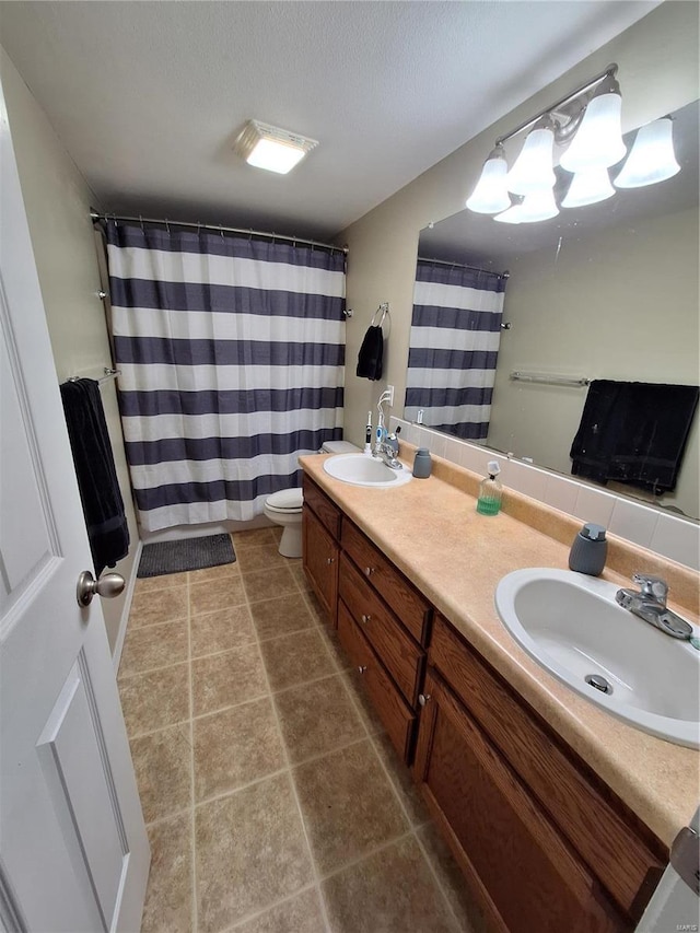 bathroom featuring a shower with curtain, vanity, toilet, and a textured ceiling