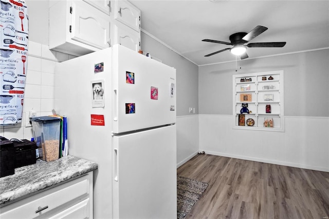 kitchen featuring light wood-type flooring, white fridge, white cabinetry, and ornamental molding