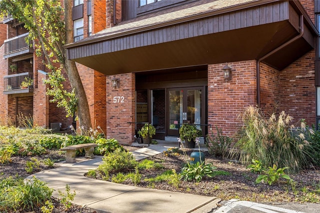 view of exterior entry featuring french doors and central AC