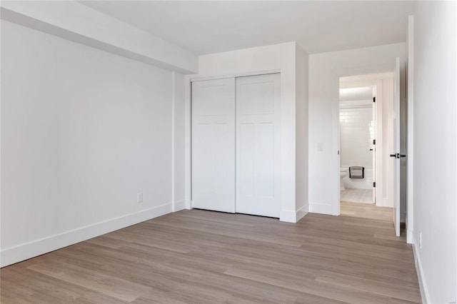 unfurnished bedroom featuring a closet and light wood-type flooring