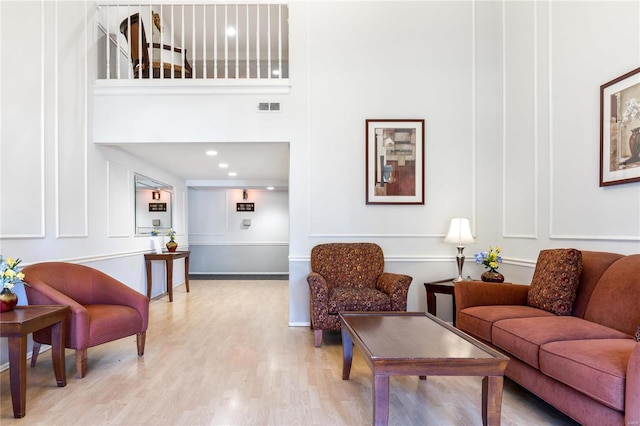 living room featuring light hardwood / wood-style flooring and a high ceiling