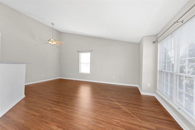 empty room featuring dark hardwood / wood-style flooring, vaulted ceiling, and ceiling fan