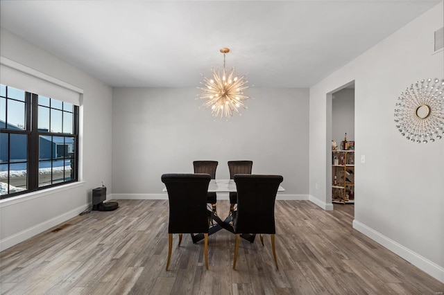 dining space with light wood-type flooring and a chandelier