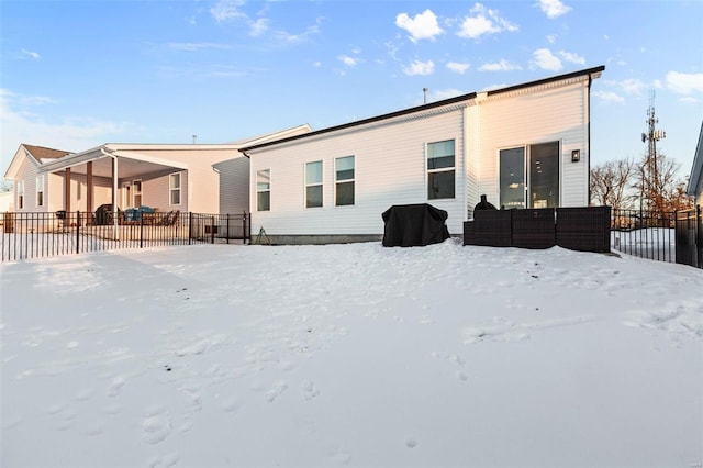 view of snow covered rear of property