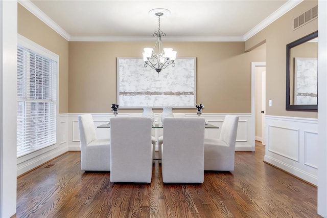 dining space with dark hardwood / wood-style flooring, crown molding, and a notable chandelier