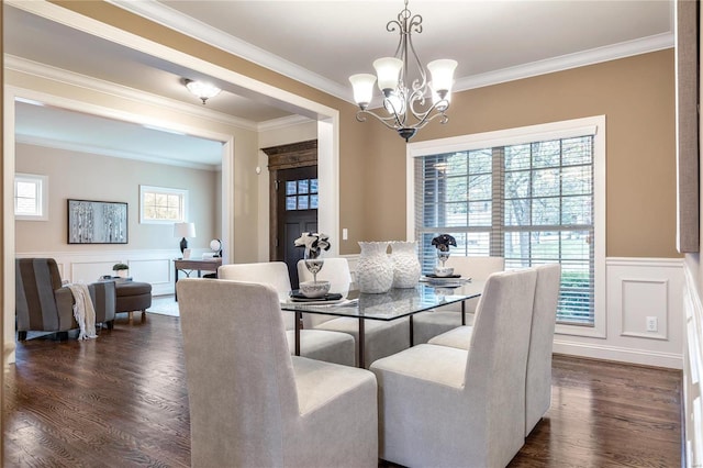 dining room featuring dark hardwood / wood-style flooring, crown molding, and a notable chandelier