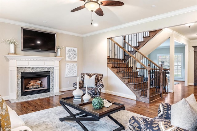 living room featuring crown molding, hardwood / wood-style floors, and a high end fireplace