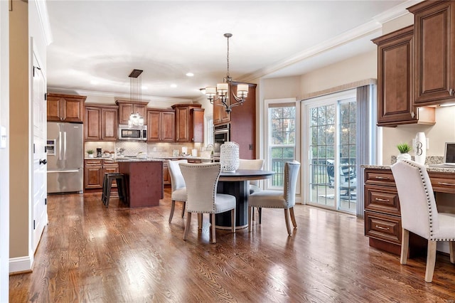 dining room featuring dark hardwood / wood-style floors, ornamental molding, and a chandelier