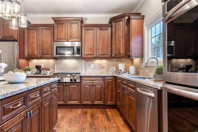 kitchen with sink, decorative backsplash, dark hardwood / wood-style flooring, light stone counters, and stainless steel appliances