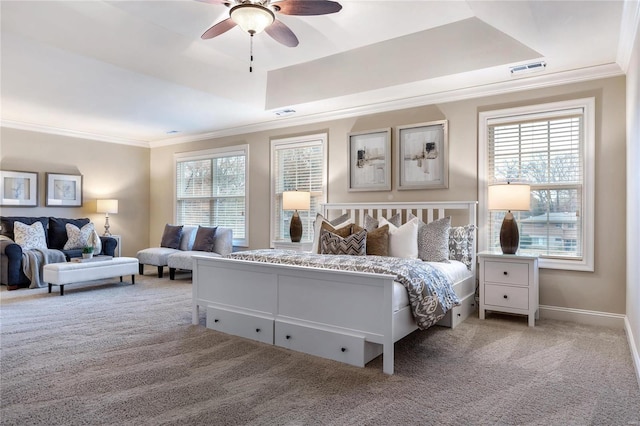 carpeted bedroom featuring ceiling fan, ornamental molding, and a tray ceiling