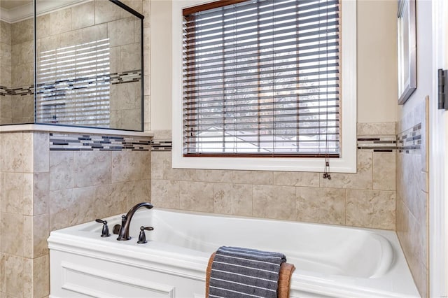 bathroom featuring a bath and tile walls