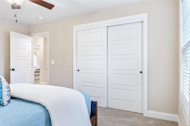 carpeted bedroom with multiple windows, a closet, and ceiling fan