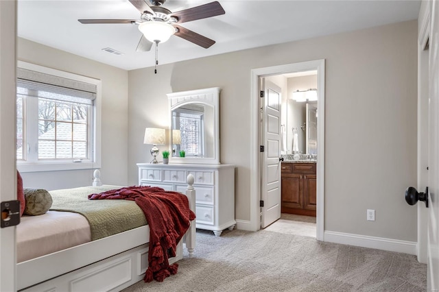 carpeted bedroom featuring ensuite bath, ceiling fan, and sink