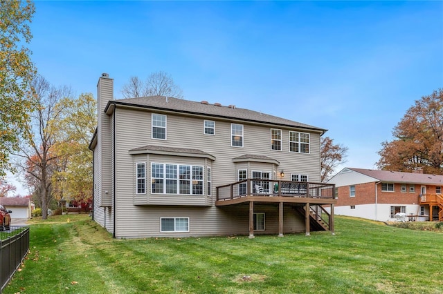 rear view of property featuring a lawn and a deck