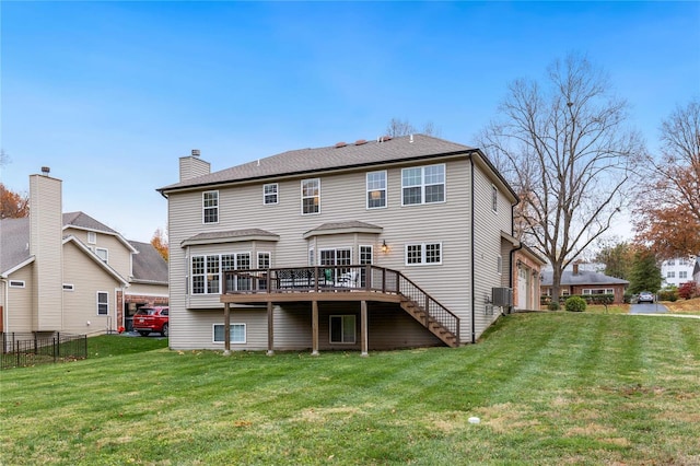 back of property with a lawn and a deck