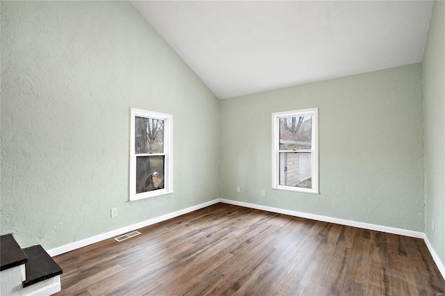 empty room with dark hardwood / wood-style floors and lofted ceiling