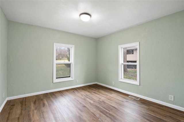 unfurnished room with wood-type flooring