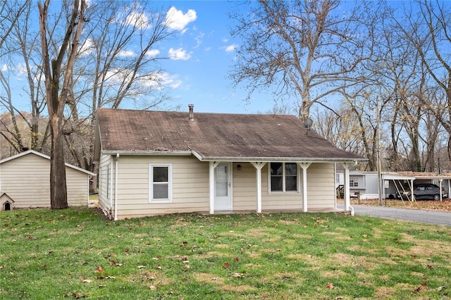 view of front of property with a front lawn and a storage shed