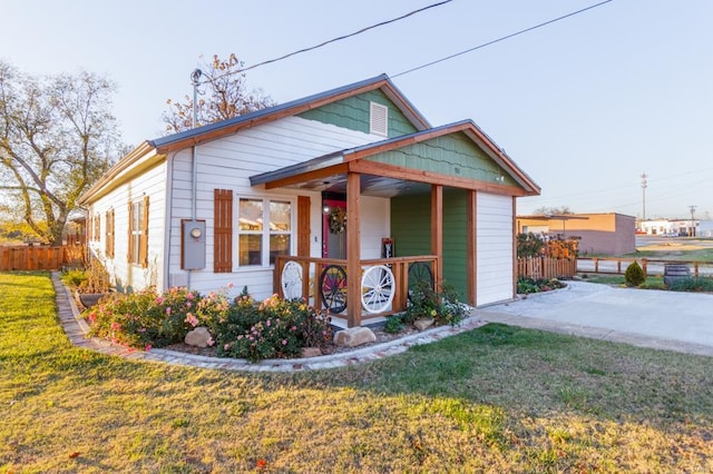 bungalow-style house featuring covered porch and a front yard