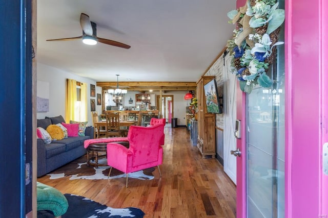 living room featuring dark hardwood / wood-style flooring and ceiling fan with notable chandelier