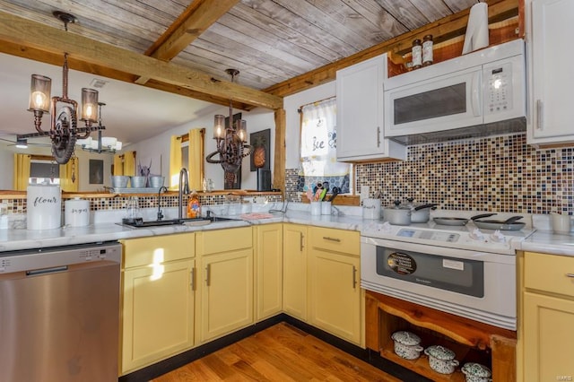 kitchen featuring backsplash, decorative light fixtures, white appliances, and light hardwood / wood-style floors