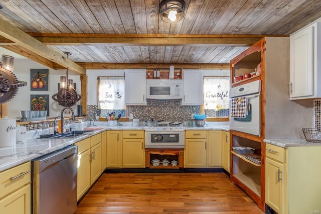 kitchen with decorative backsplash, a wealth of natural light, light hardwood / wood-style floors, and white appliances