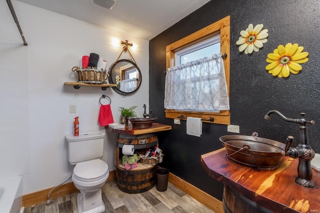 bathroom with sink, toilet, and hardwood / wood-style flooring