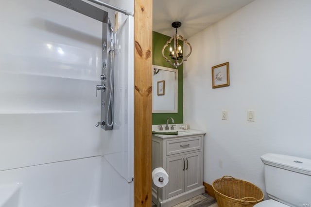 bathroom with an inviting chandelier, a shower, toilet, vanity, and hardwood / wood-style flooring