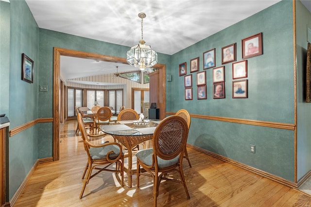 dining room with light wood-type flooring and an inviting chandelier