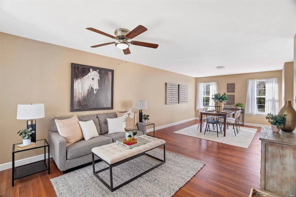 living room featuring ceiling fan and dark wood-type flooring