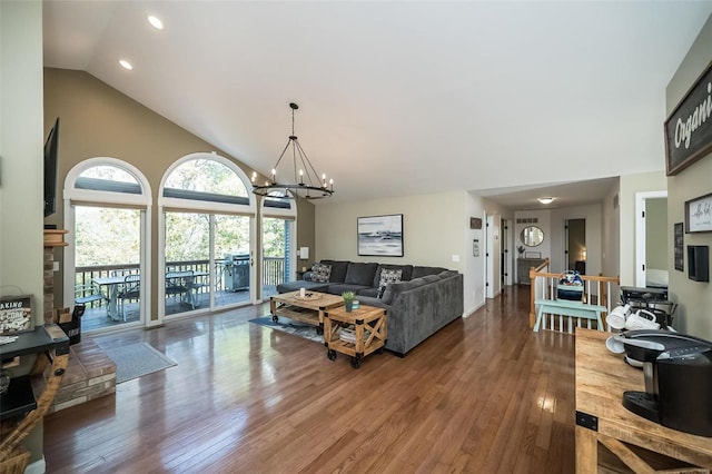 living room featuring a chandelier, hardwood / wood-style floors, and high vaulted ceiling