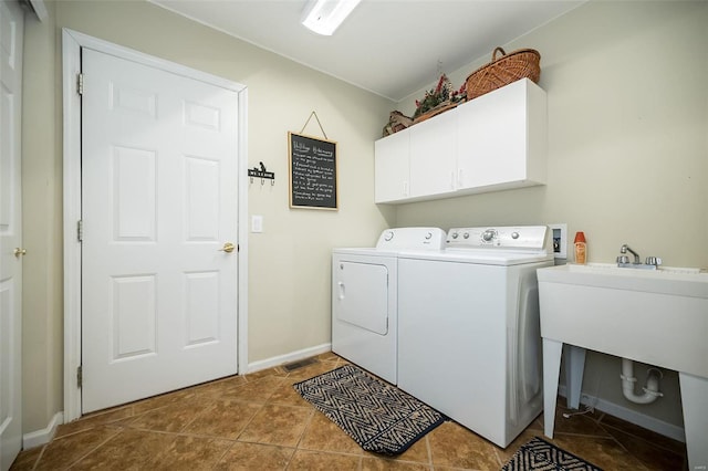 laundry room with cabinets, light tile patterned flooring, and washer and dryer