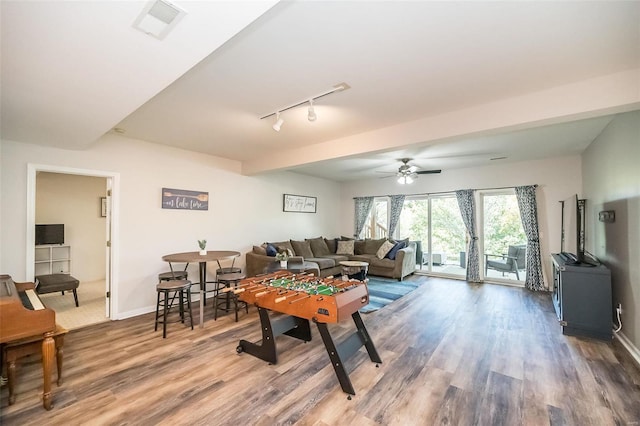 recreation room with hardwood / wood-style floors, rail lighting, and ceiling fan