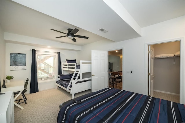 carpeted bedroom featuring ceiling fan and a spacious closet