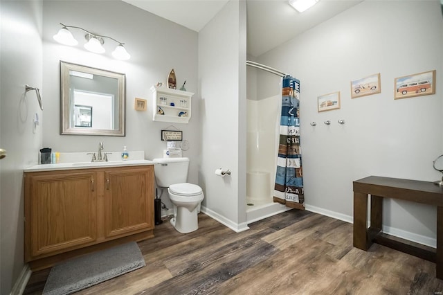 bathroom with a shower with shower curtain, hardwood / wood-style floors, vanity, and toilet