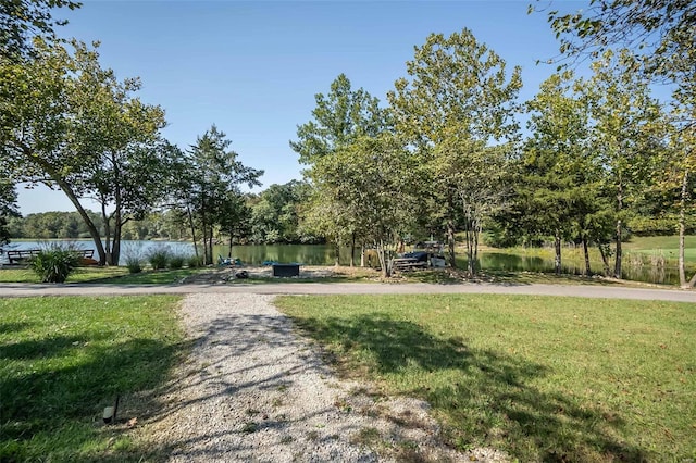 surrounding community with a yard and a water view