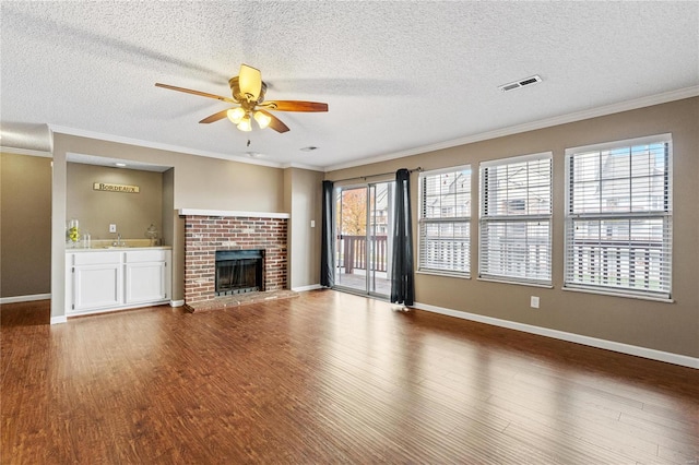 unfurnished living room with hardwood / wood-style flooring, plenty of natural light, and a brick fireplace