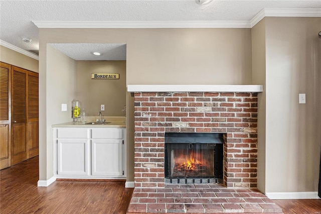 interior space featuring white cabinetry, sink, wood-type flooring, and a textured ceiling