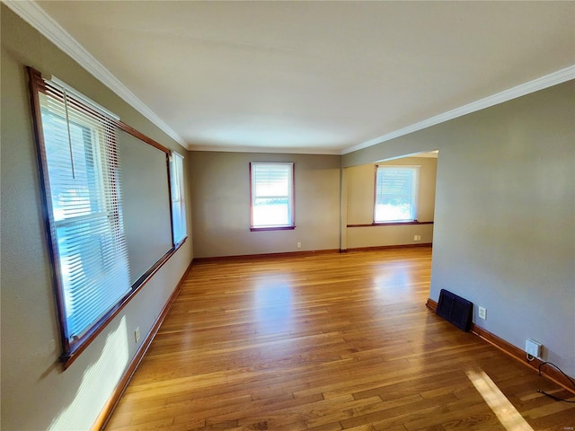 unfurnished room featuring light hardwood / wood-style floors and crown molding