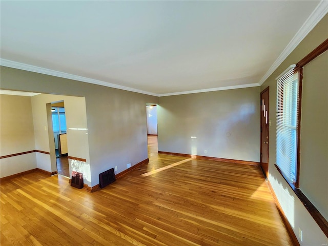 unfurnished room featuring crown molding, a healthy amount of sunlight, and hardwood / wood-style flooring